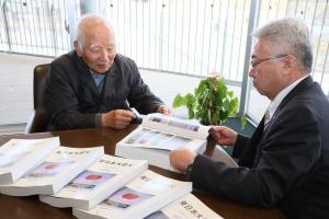 当時の写真に目を通す橋元町長